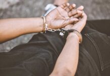 Person in handcuffs with hands behind back.