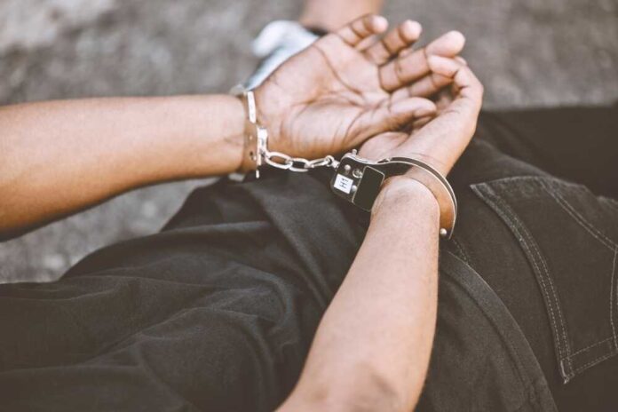 shutterstock_2224946127.jpg featured image Person in handcuffs with hands behind back.
