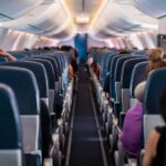 Airplane interior with passengers seated mid-flight.