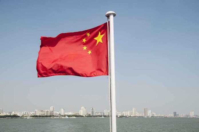 747546298 featured image Chinese flag waving over cityscape and water.