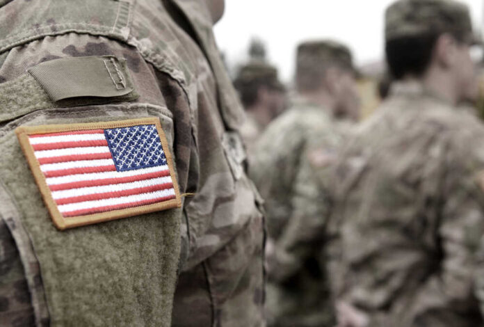 shutterstock_18369768851.jpg featured image U.S. soldiers in camouflage uniforms with American flag patch.