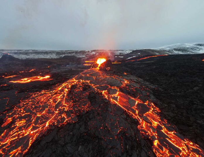 shutterstock_1958468116.jpg featured image Lava flowing from volcanic eruption under gray sky