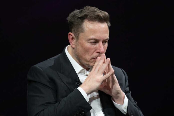 shutterstock_2318800313-1.jpg featured image Elon Musk in a suit deep in thought, black background.
