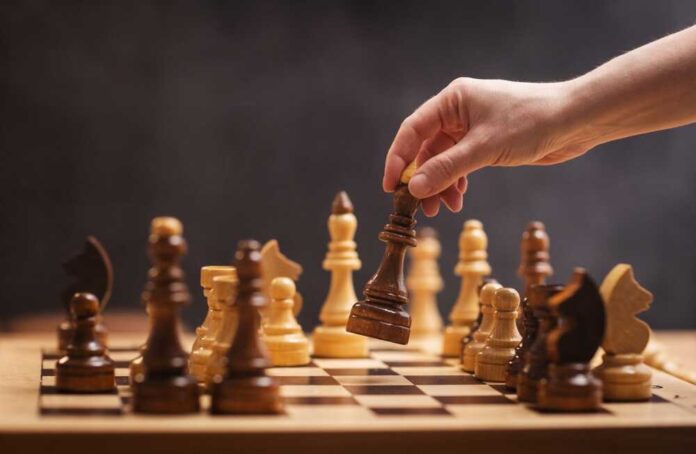 shutterstock_2463856077.jpg featured image Hand moving chess piece during a game
