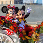 Mickey and Minnie Mouse waving from decorated carriage.