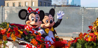 Mickey and Minnie Mouse waving from decorated carriage.