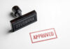 Rubber stamp with the word approved stamped nearby