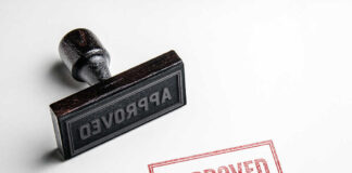Rubber stamp with the word approved stamped nearby