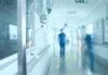 Hospital corridor with IV drip and healthcare worker.