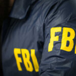 FBI agent in navy blue jacket.