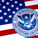 US Immigration and Customs Enforcement badge on flag