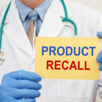 Doctor holding a product recall sign in gloves