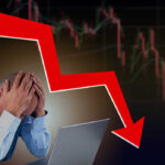 Man stressed over falling stock market graph.
