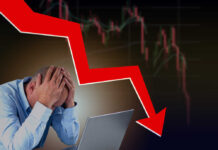 Man stressed over falling stock market graph.