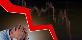 Man stressed over falling stock market graph.