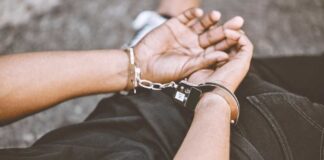 Person in handcuffs with hands behind back.