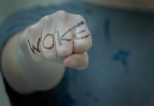 Fist with Woke written on fingers