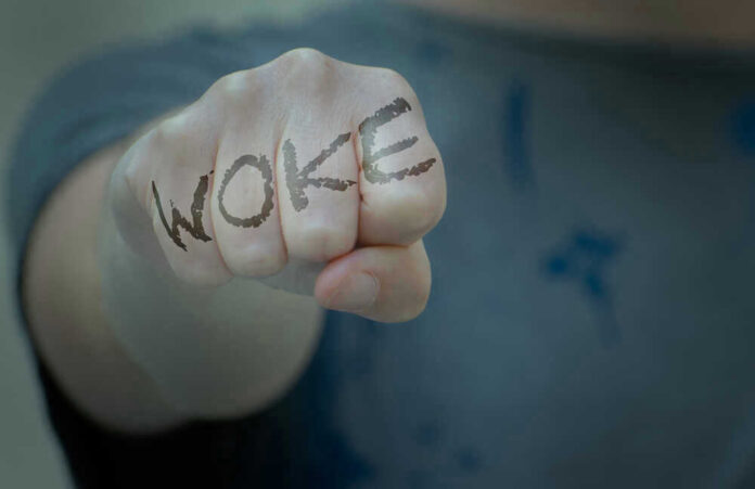 shutterstock_2002018643.jpg Fist with Woke written on fingers