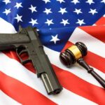 Gun and gavel on a U.S. flag.