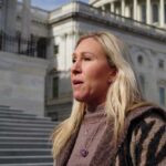 Marjorie Taylor Greene standing outside a large building.