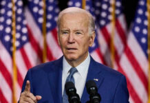 Joe Biden speaking with American flags behind