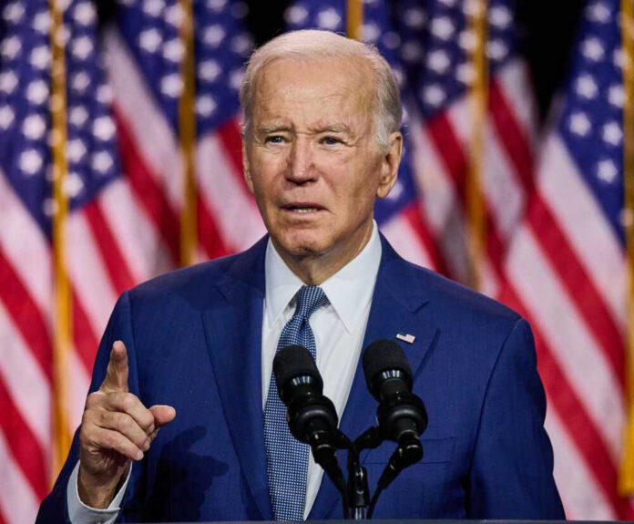 shutterstock_2307248525.jpg Joe Biden speaking with American flags behind