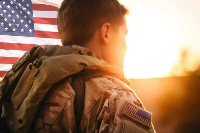 Soldier in uniform with American flag at sunset