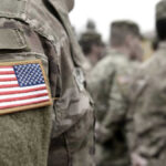 Soldiers in camouflage uniforms with American flag patches