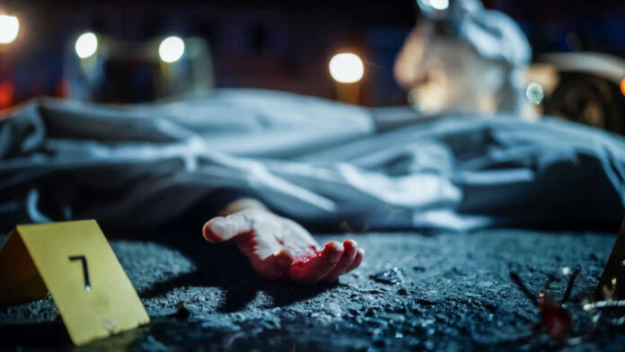 Crime scene with covered body and hand exposed