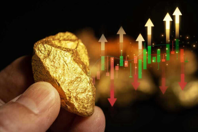 Hand holding gold nugget with financial market chart