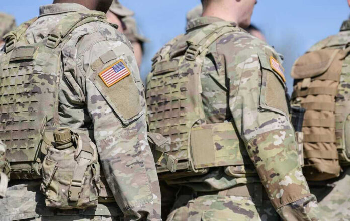 Soldiers in camouflage uniforms with American flag patches.