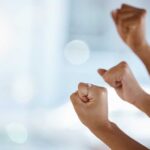 Hands with clenched fists raised in celebration