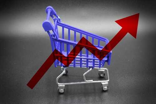 A miniature shopping cart with a rising arrow in the background