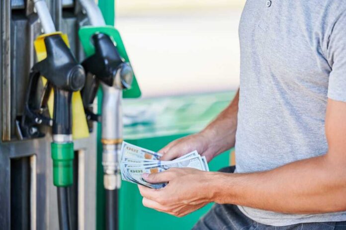 Man holding cash at a gas station