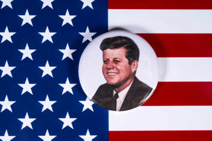 A button featuring a portrait of John F. Kennedy on a background of the American flag