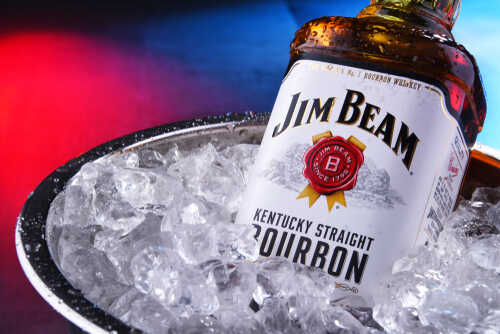 A bottle of Jim Beam bourbon whiskey partially submerged in ice