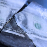 A dollar bill partially encased in ice