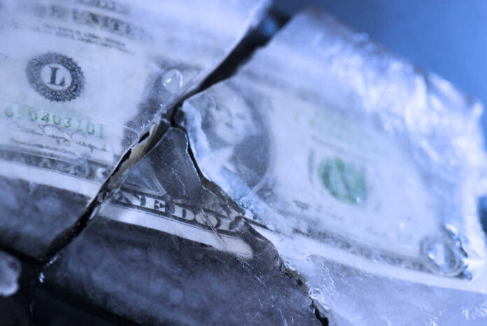 A dollar bill partially encased in ice