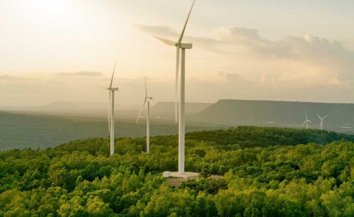 shutterstock_2203542663.jpg Wind turbines on a hillside during sunset