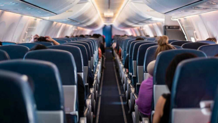 Airplane interior with passengers seated mid-flight.