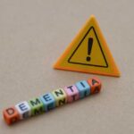 Dementia Shocker Stuns Senate Colleagues Colorful letter blocks spelling 'DEMENTIA' next to a warning sign
