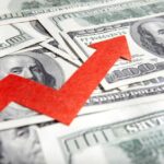 A red arrow indicating growth over scattered hundred dollar bills