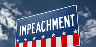 A sign displaying the word 'IMPEACHMENT' against a cloudy sky