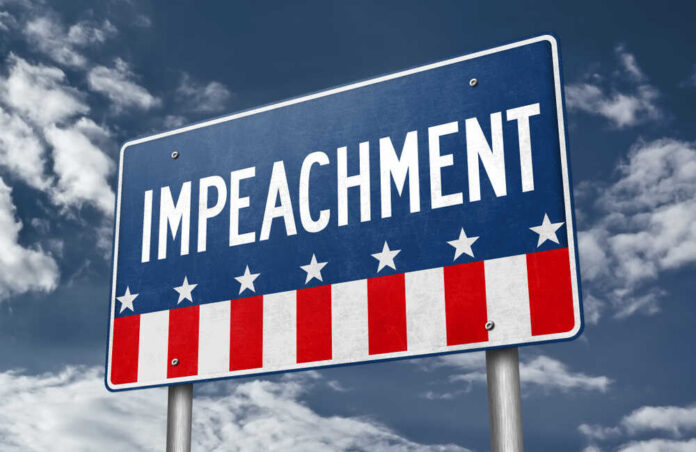 A sign displaying the word 'IMPEACHMENT' against a cloudy sky