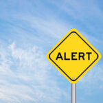 Trump Slams Brakes on Child Care Ripoffs Yellow alert sign against a blue sky