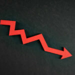 Red zigzag arrow pointing down on dark background.