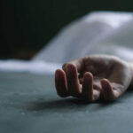 Dead persons hand lying on a gray surface