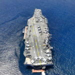 Aircraft carrier on open sea with parked planes