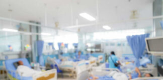 Blurred hospital room with multiple patients and nurses