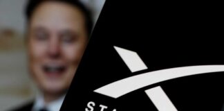 Close-up of the Starlink logo with a blurred figure in the background
